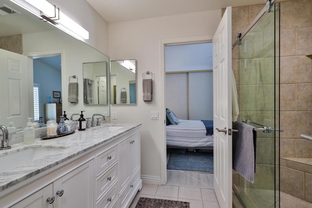 bathroom with a shower with shower door, vanity, and tile patterned flooring