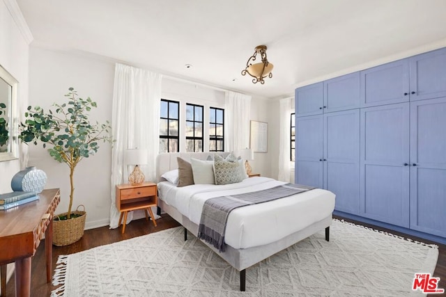 bedroom featuring ornamental molding and hardwood / wood-style flooring