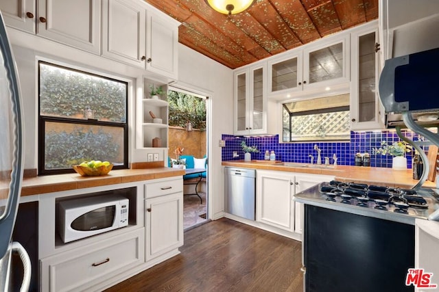 kitchen featuring dark hardwood / wood-style floors, decorative backsplash, sink, white cabinetry, and stainless steel appliances