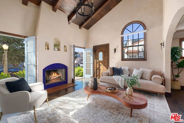 living room featuring a tile fireplace, beam ceiling, wood ceiling, high vaulted ceiling, and dark hardwood / wood-style flooring