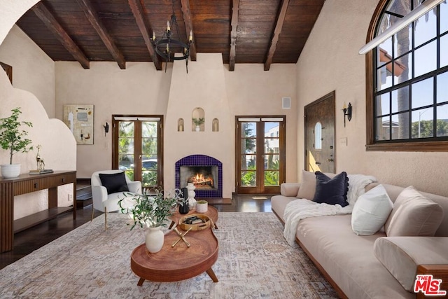 living room featuring dark hardwood / wood-style flooring, wood ceiling, french doors, and a tile fireplace