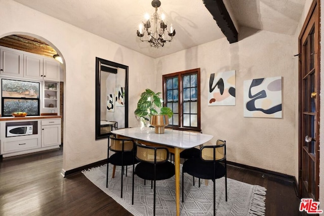 dining room with dark wood-type flooring, a chandelier, and beam ceiling