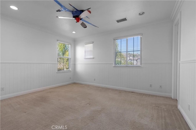 carpeted empty room with ceiling fan and ornamental molding