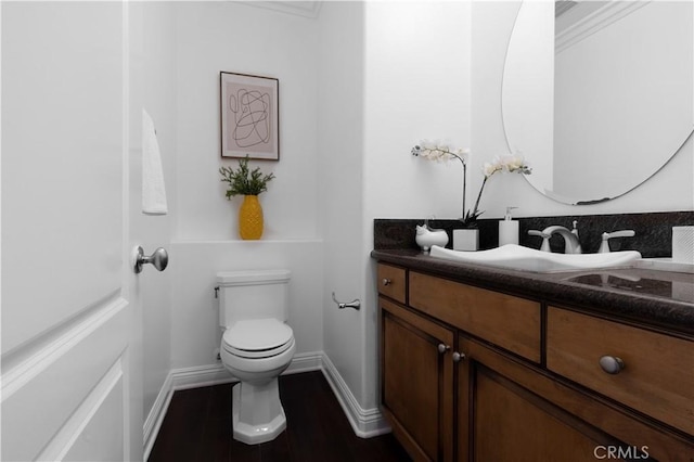 bathroom featuring toilet, ornamental molding, and vanity