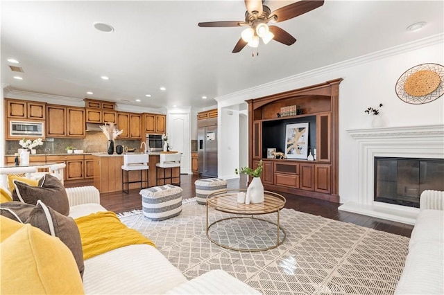 living room with ceiling fan, dark wood-type flooring, and crown molding