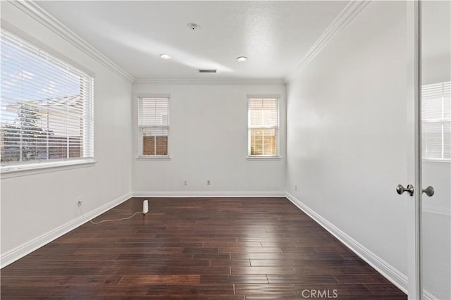 empty room featuring dark hardwood / wood-style flooring and ornamental molding