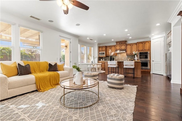 living room with ceiling fan, wood-type flooring, and crown molding