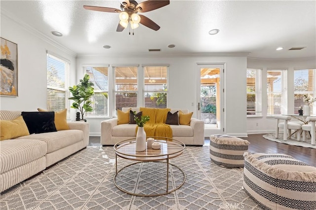 living room featuring hardwood / wood-style flooring, plenty of natural light, ornamental molding, and ceiling fan