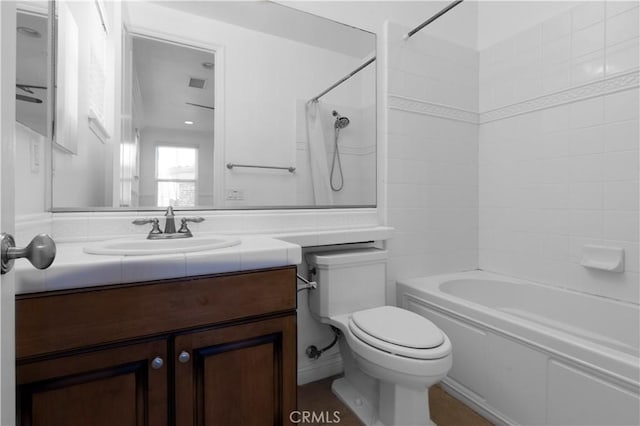 full bathroom featuring toilet, vanity, and tiled shower / bath