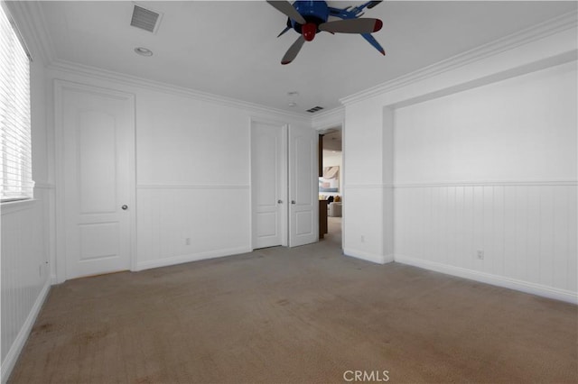 unfurnished bedroom with ceiling fan, crown molding, and carpet flooring