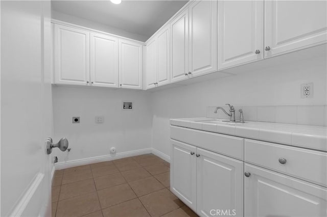 washroom with light tile patterned floors, hookup for a gas dryer, electric dryer hookup, hookup for a washing machine, and cabinets