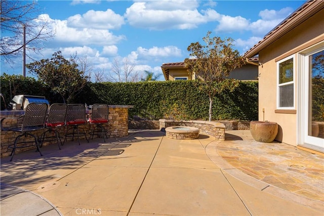 view of patio / terrace with exterior bar and a fire pit