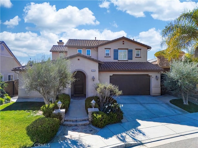 mediterranean / spanish house with a front yard and a garage