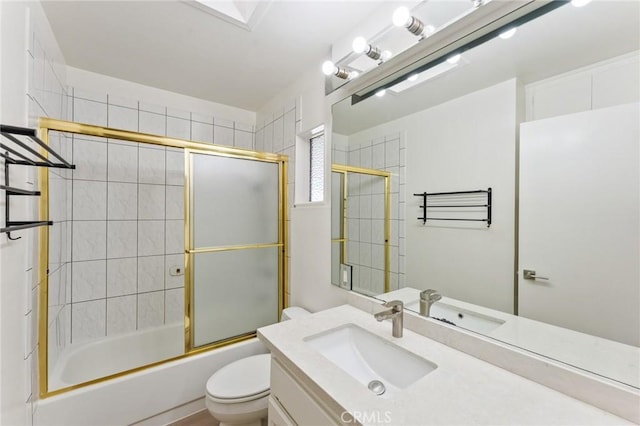 full bathroom featuring toilet, bath / shower combo with glass door, and vanity