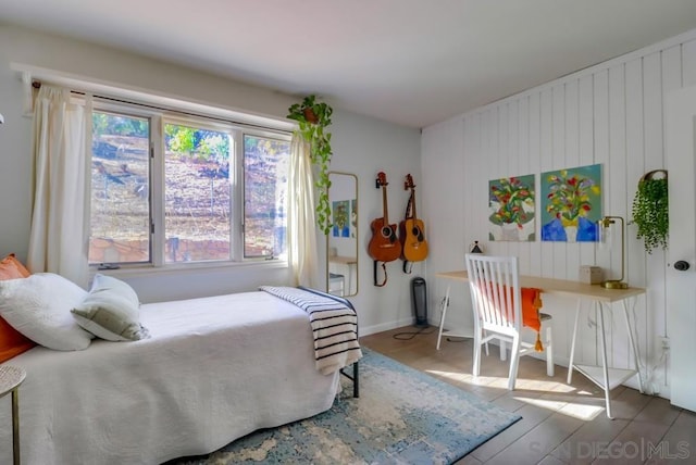 bedroom with multiple windows and hardwood / wood-style floors