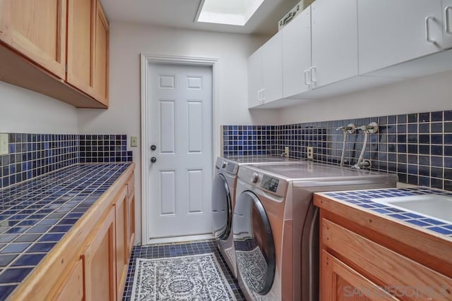 laundry area featuring cabinets, tile patterned floors, and washing machine and clothes dryer