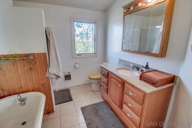 bathroom featuring toilet, heating unit, tile patterned floors, a washtub, and vanity