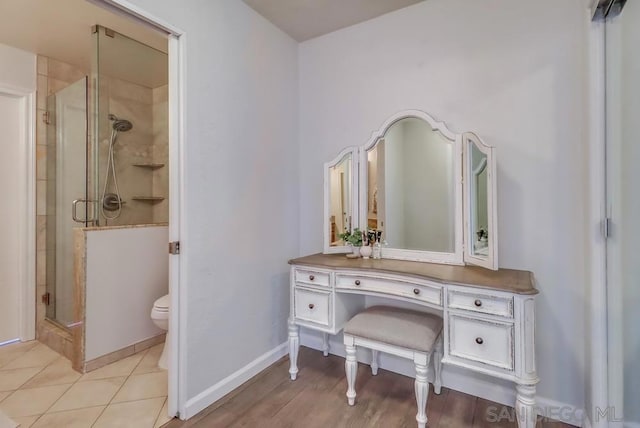 bathroom with toilet, tile patterned flooring, an enclosed shower, and vanity