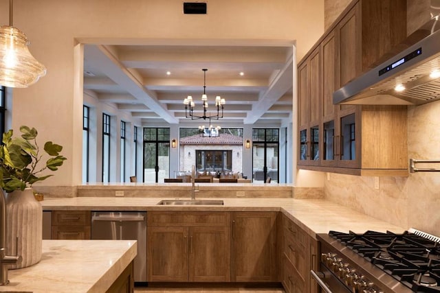 kitchen with an inviting chandelier, appliances with stainless steel finishes, sink, wall chimney range hood, and beamed ceiling