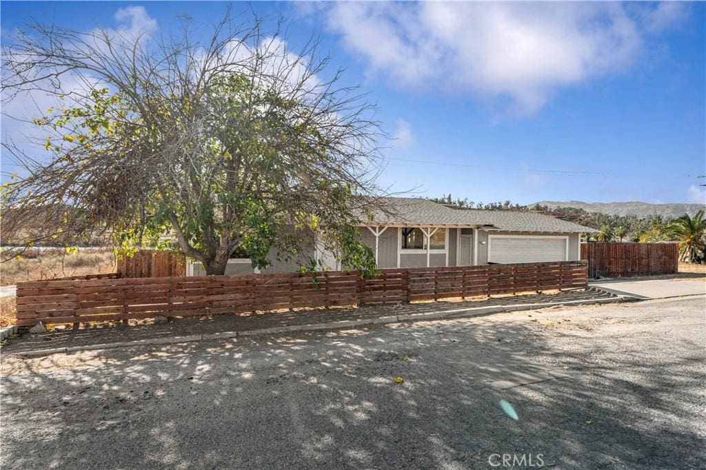 view of front of property with a garage, a fenced front yard, and a mountain view