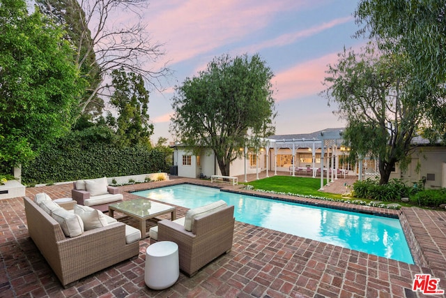 pool at dusk with a pergola, a patio area, outdoor lounge area, and an outdoor structure