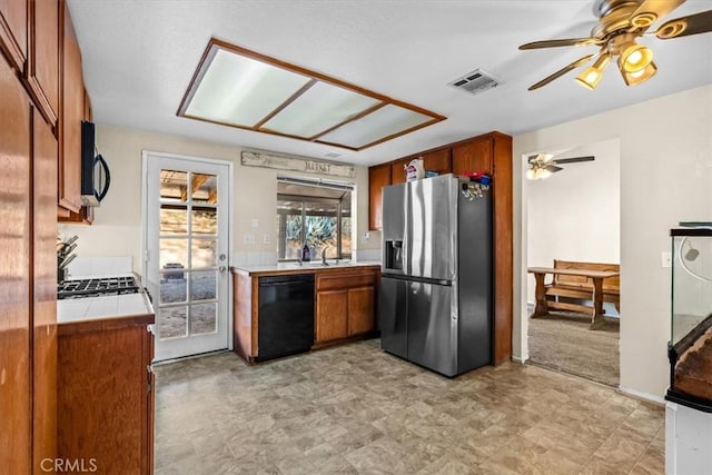 kitchen with ceiling fan, tile countertops, sink, and black appliances