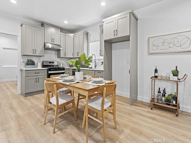 kitchen with stainless steel range with gas cooktop, gray cabinetry, sink, and light wood-type flooring