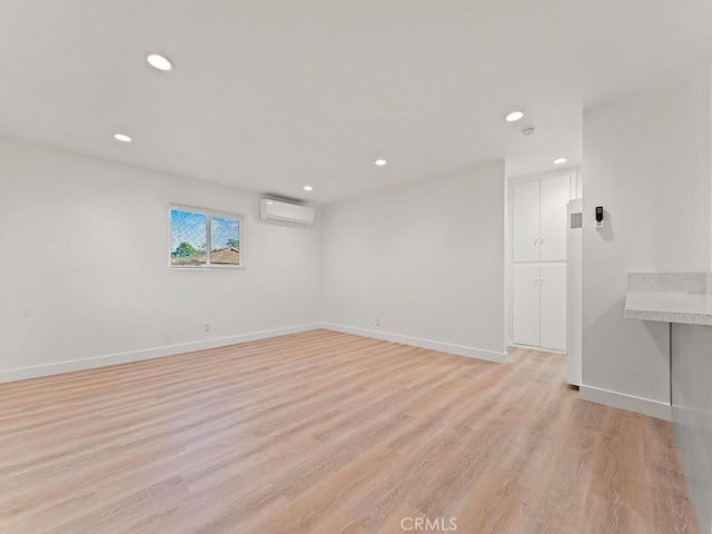 interior space with light hardwood / wood-style floors and a wall mounted air conditioner