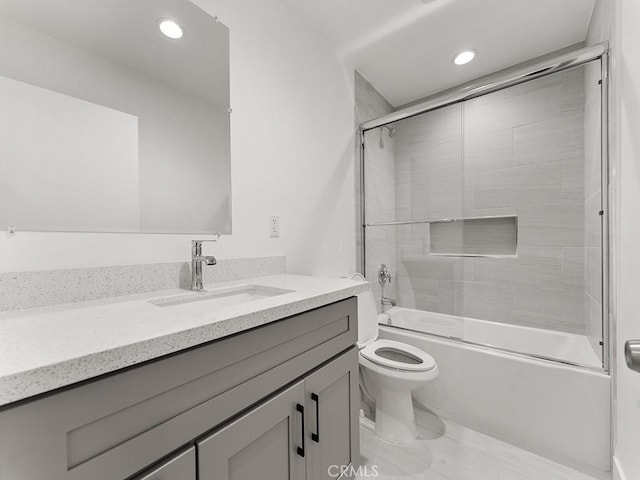 full bathroom featuring combined bath / shower with glass door, vanity, and toilet