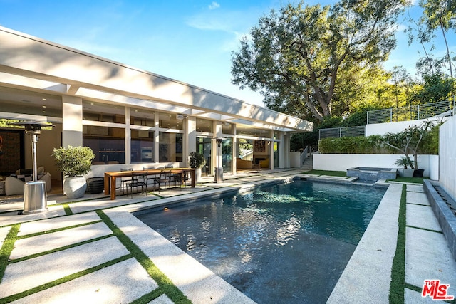 view of swimming pool featuring a patio area and exterior bar