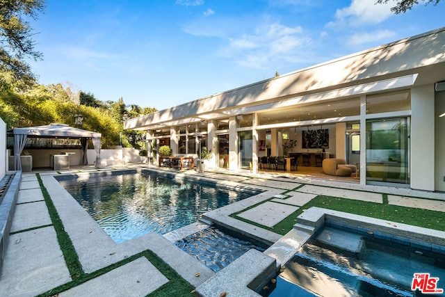 view of pool with an outdoor bar, a patio area, and an in ground hot tub