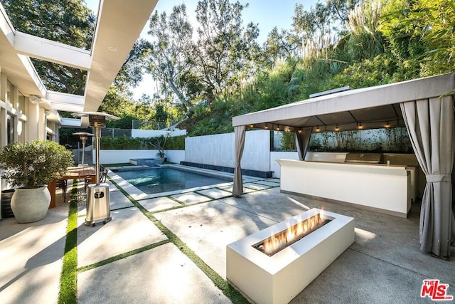 view of pool featuring an outdoor fire pit, a gazebo, and a patio area