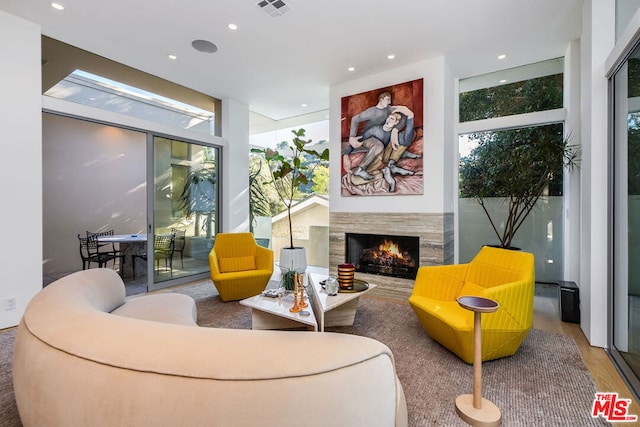 living room featuring a wall of windows, a premium fireplace, and hardwood / wood-style floors