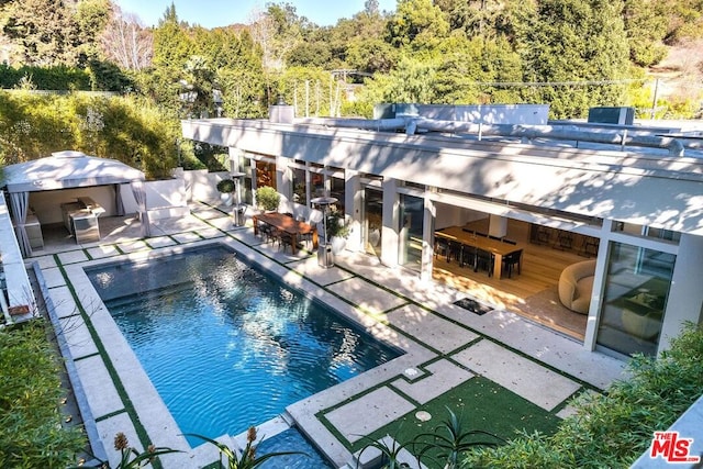 view of pool with exterior bar and a patio area