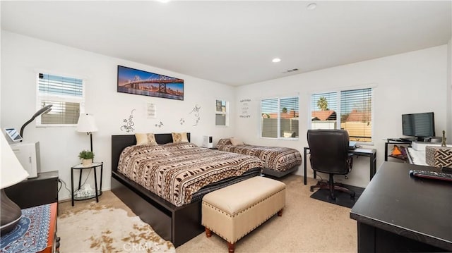 bedroom featuring multiple windows, visible vents, and carpet flooring