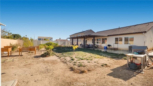 rear view of property with a patio, a fenced backyard, cooling unit, a garden, and a tiled roof