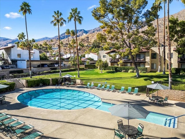 view of pool with a mountain view, a lawn, and a patio