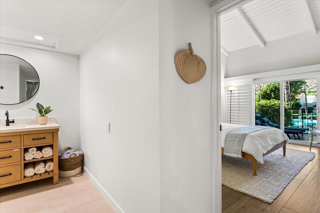 bathroom featuring wood-type flooring, vanity, and lofted ceiling with beams