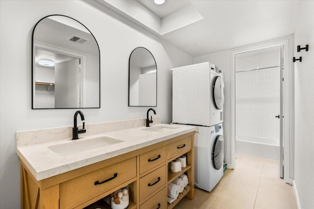 bathroom featuring bathing tub / shower combination, stacked washer and clothes dryer, vanity, and tile patterned flooring