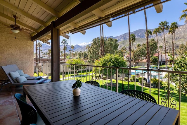 exterior space with ceiling fan, vaulted ceiling with beams, and a mountain view