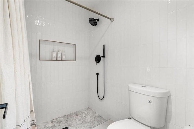 bathroom with tile walls, toilet, and a shower with shower curtain