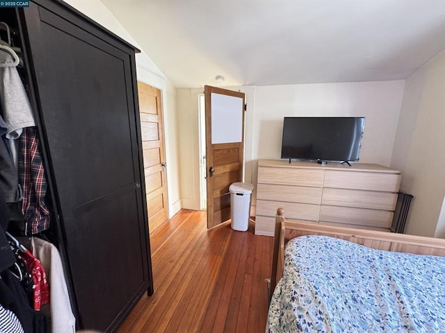 bedroom with dark hardwood / wood-style floors and lofted ceiling