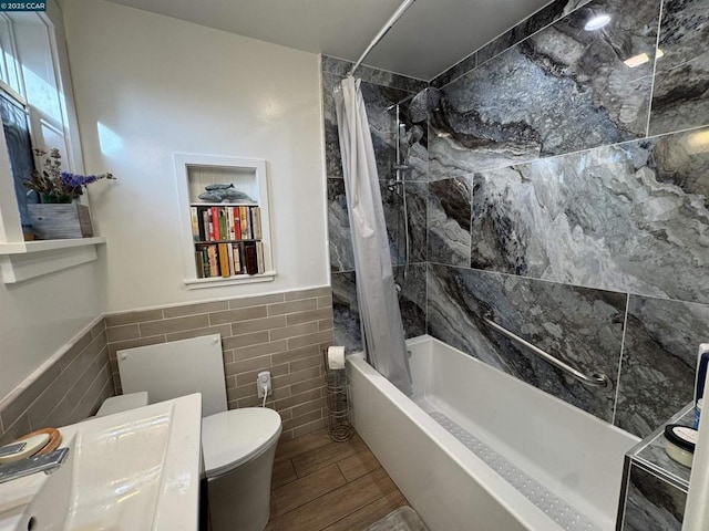 full bathroom with sink, tile walls, toilet, and shower / tub combo with curtain