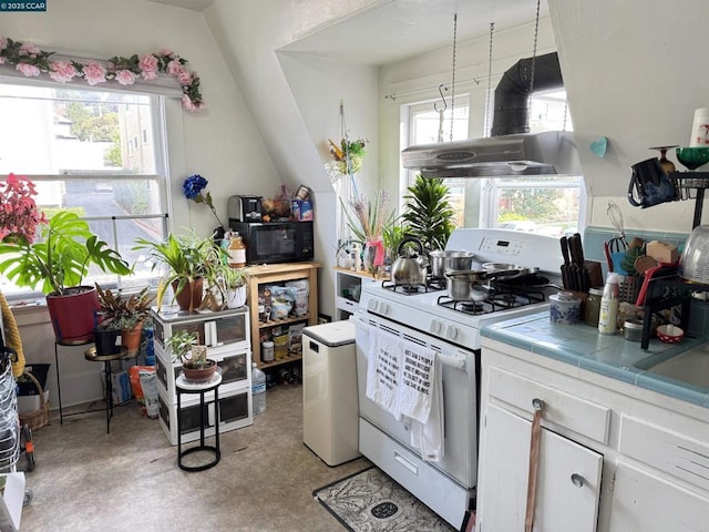 kitchen with tile countertops, white cabinetry, island range hood, a healthy amount of sunlight, and white gas range