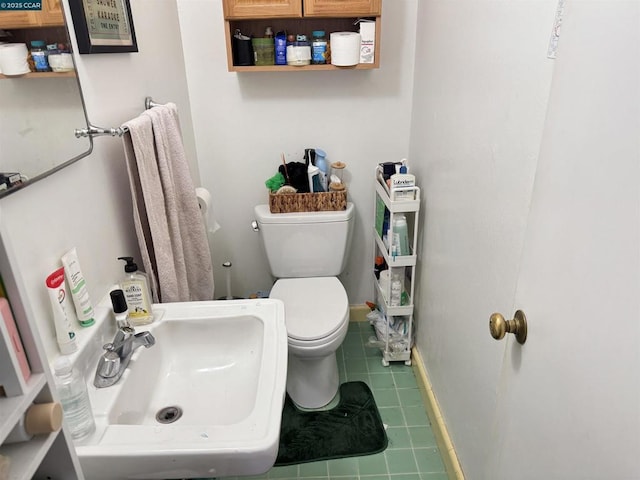 bathroom with toilet, tile patterned floors, and sink