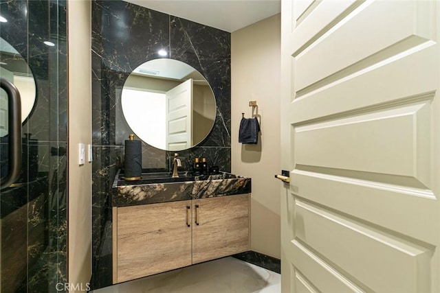 bathroom featuring a shower, tile walls, and vanity