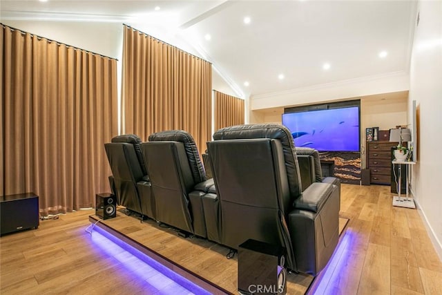 cinema featuring light hardwood / wood-style floors, crown molding, and vaulted ceiling