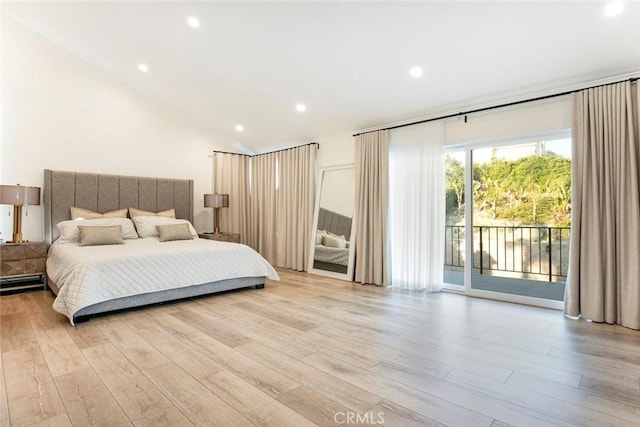 bedroom featuring light hardwood / wood-style floors, lofted ceiling, and access to outside