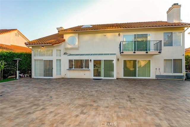 rear view of house featuring a patio area and a balcony