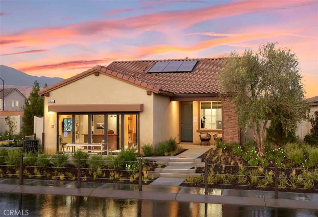 back house at dusk featuring a mountain view and solar panels